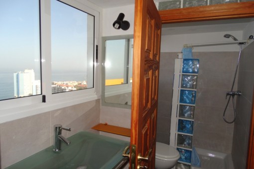 Bathroom has large windows and clear sea view